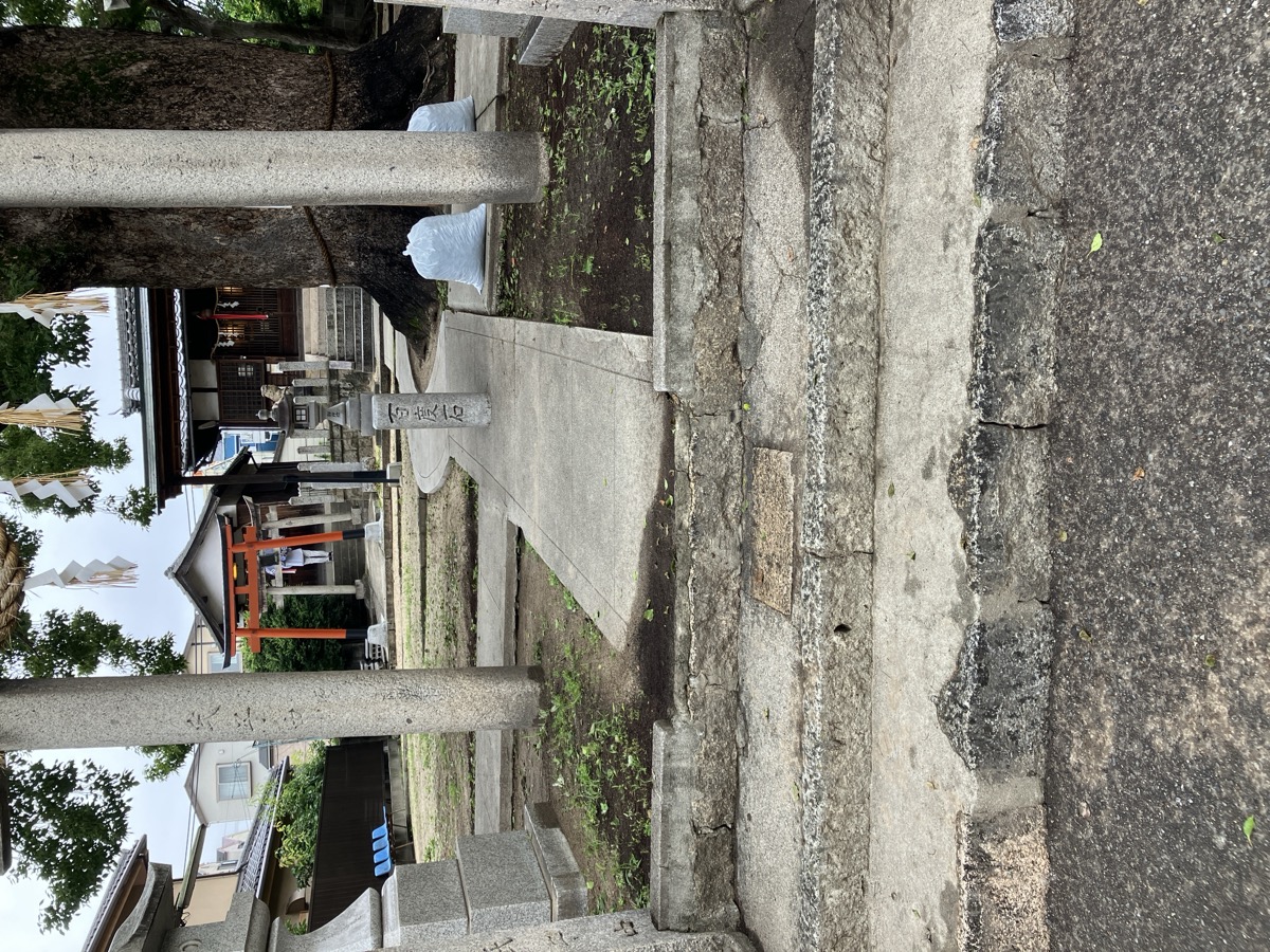 清掃後の神社境内。参道がすっきりと整い、袋に集めた落ち葉や草も見える