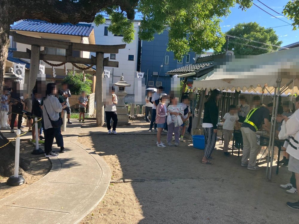 神社の境内に、抽選会の発表を待つ人たちが集まっている